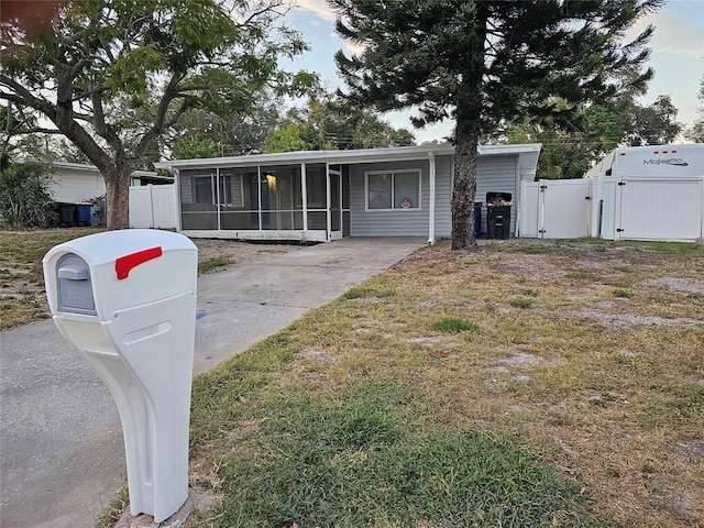 view of front of property with a sunroom and a front lawn