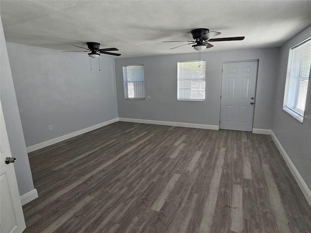 empty room featuring a textured ceiling and dark hardwood / wood-style floors