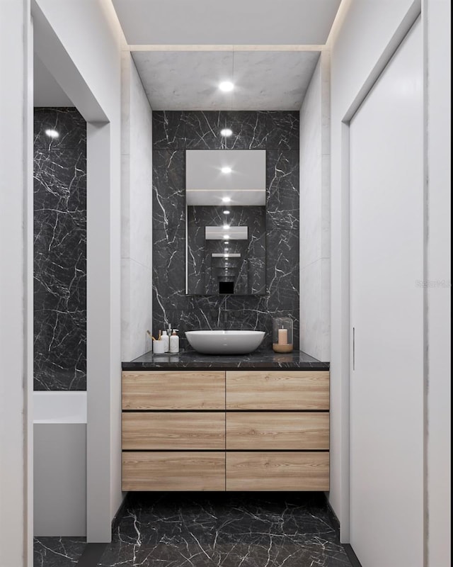 bathroom featuring vanity and tile walls