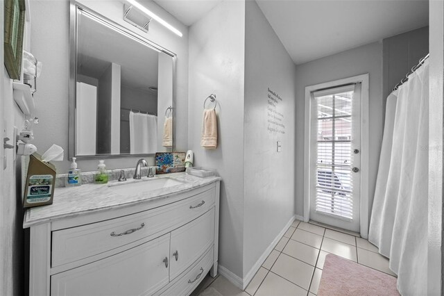 full bath featuring vanity, baseboards, and tile patterned floors