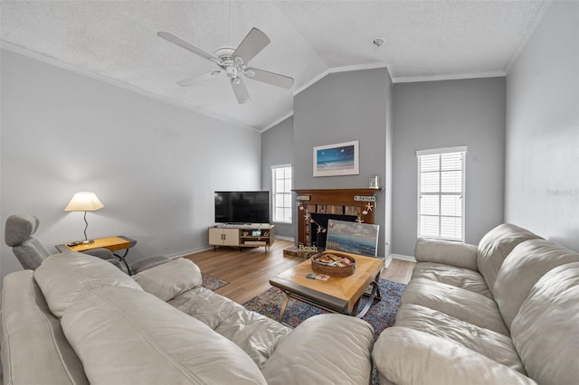 living area featuring vaulted ceiling, plenty of natural light, wood finished floors, and a brick fireplace