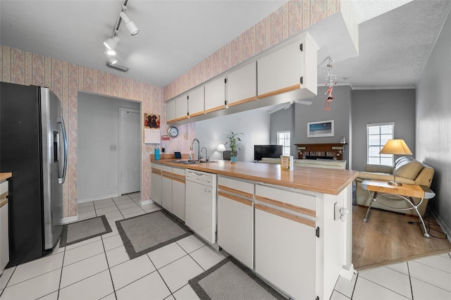 kitchen with freestanding refrigerator, open floor plan, dishwasher, a peninsula, and wallpapered walls