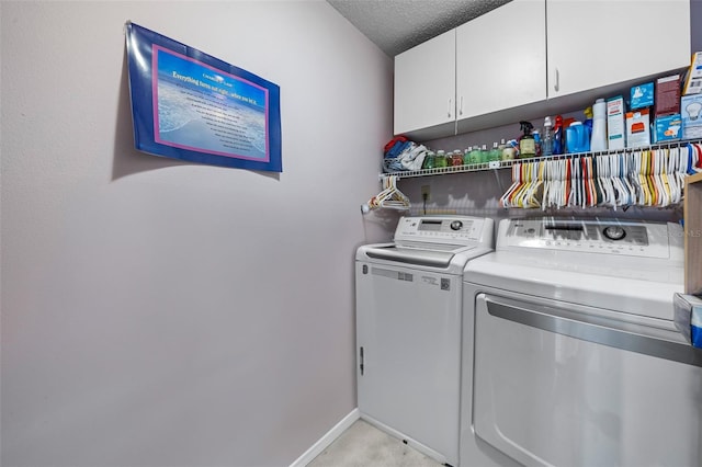 clothes washing area featuring cabinet space, baseboards, separate washer and dryer, and a textured ceiling