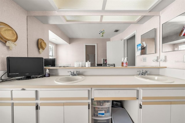 bathroom with double vanity, a sink, and visible vents