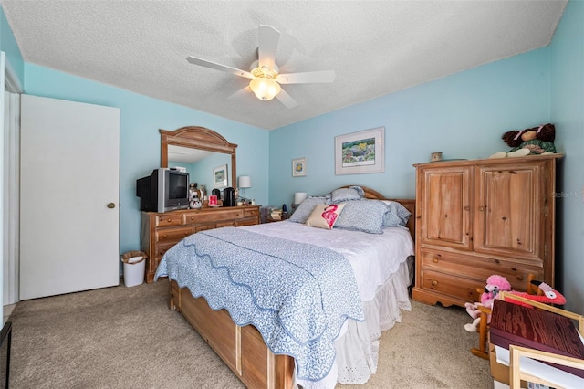 bedroom featuring light carpet, a ceiling fan, and a textured ceiling