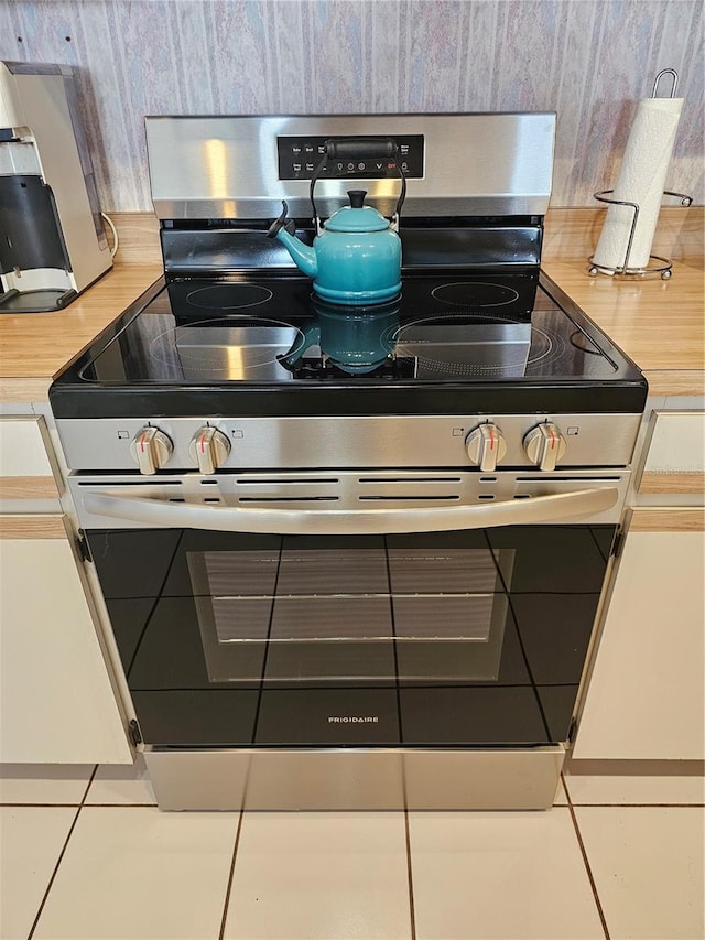 details featuring stainless steel electric range oven, light countertops, and decorative backsplash