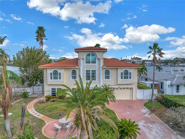 mediterranean / spanish house with a garage and a water view