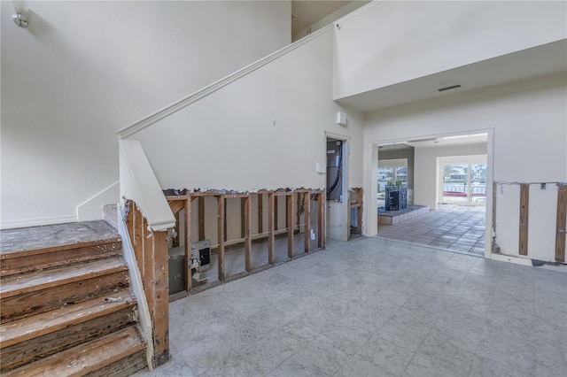 stairway with a fireplace and a high ceiling