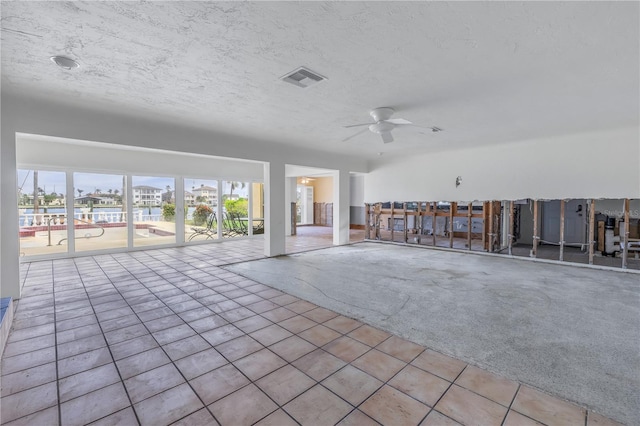 interior space featuring a textured ceiling, ceiling fan, and light carpet