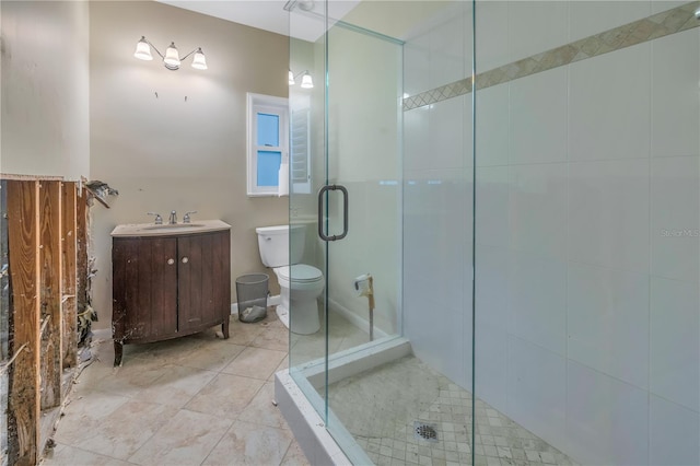 bathroom featuring vanity, toilet, and a shower with door