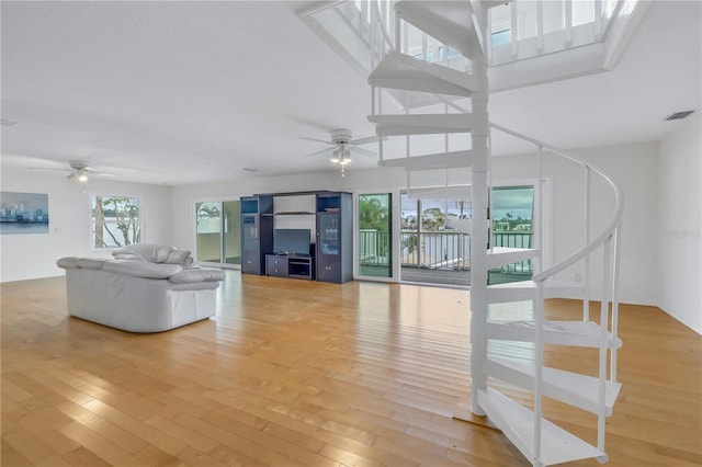 unfurnished living room with wood-type flooring and ceiling fan