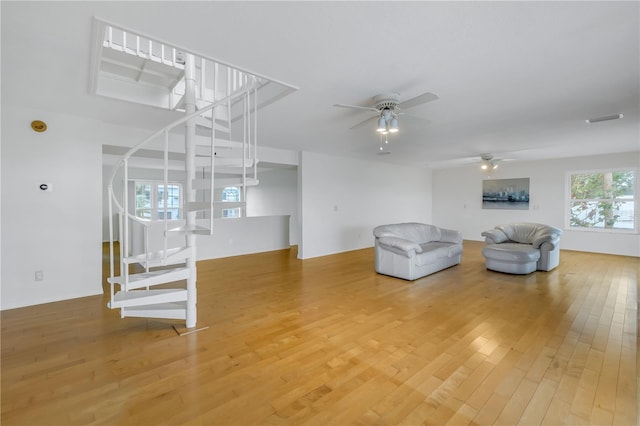 unfurnished living room with wood-type flooring and ceiling fan