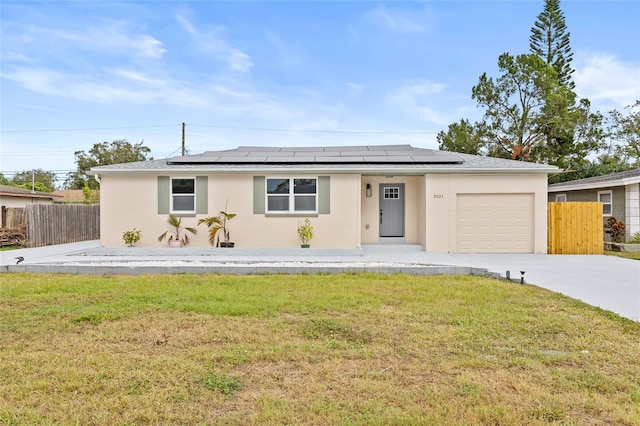 ranch-style house with a front lawn, a garage, and solar panels