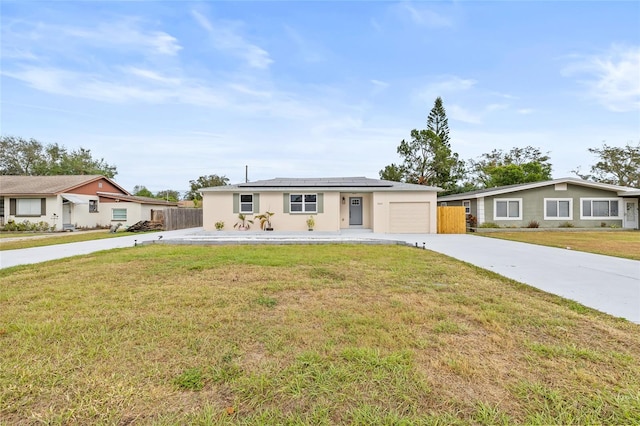 single story home with solar panels, a garage, and a front yard