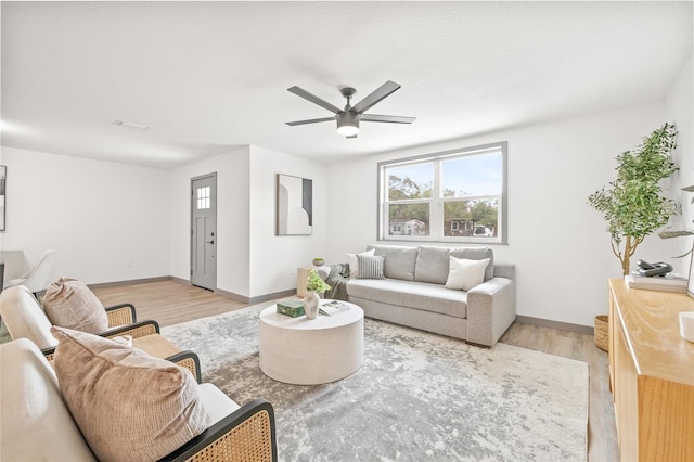 living room featuring ceiling fan and light hardwood / wood-style flooring