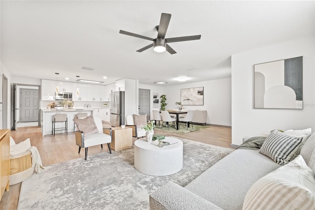 living room with ceiling fan and light hardwood / wood-style floors