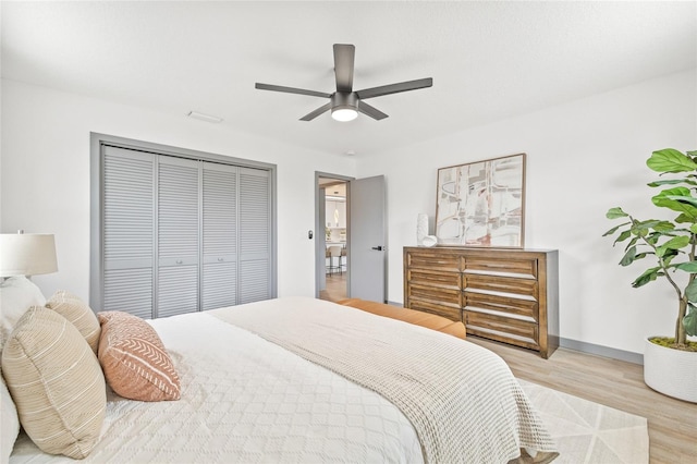 bedroom featuring light wood-type flooring, a closet, and ceiling fan