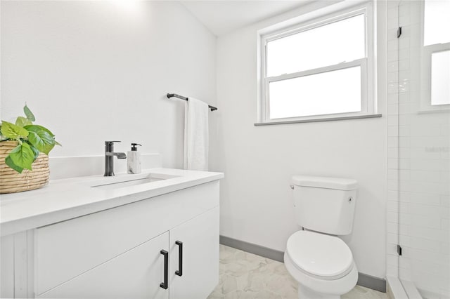 bathroom with vanity, toilet, and tiled shower