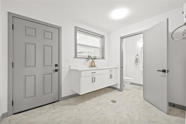 bathroom featuring vanity, toilet, and a textured ceiling