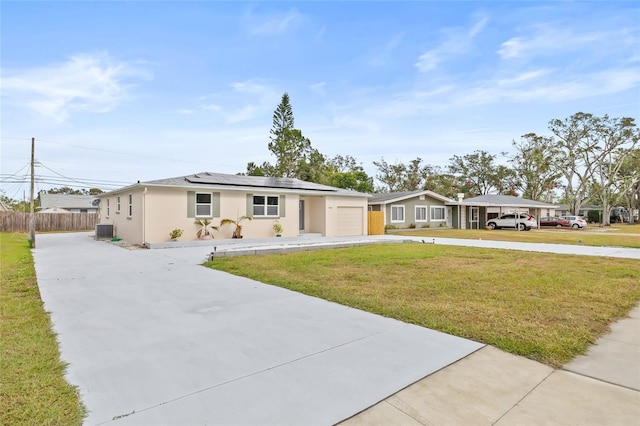 ranch-style house with solar panels, a garage, central air condition unit, and a front lawn