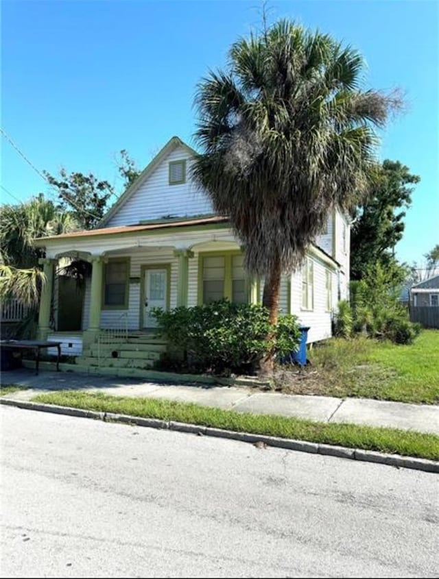 view of front of property with covered porch and a front lawn