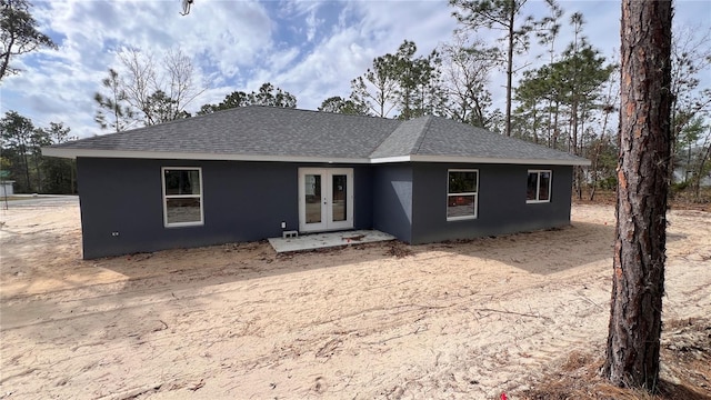 single story home with french doors, roof with shingles, and stucco siding