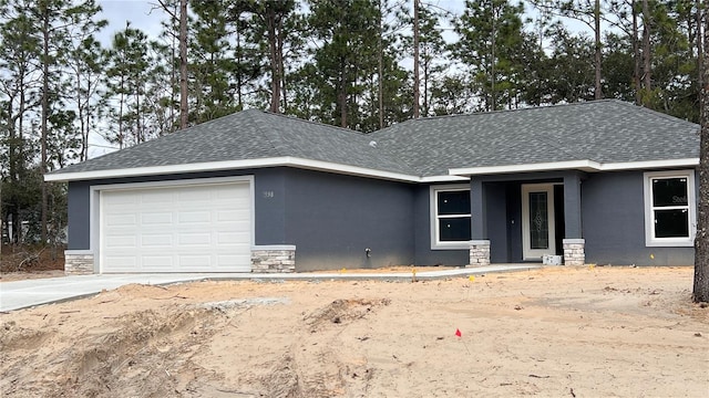 single story home with stone siding, a shingled roof, an attached garage, and stucco siding