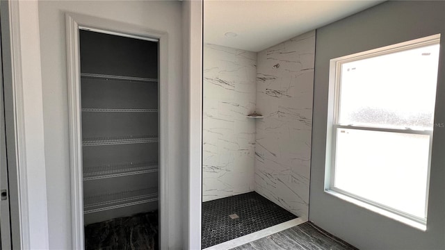 bathroom featuring a spacious closet and walk in shower