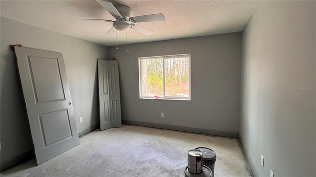 unfurnished bedroom with a ceiling fan, unfinished concrete floors, baseboards, and a textured ceiling