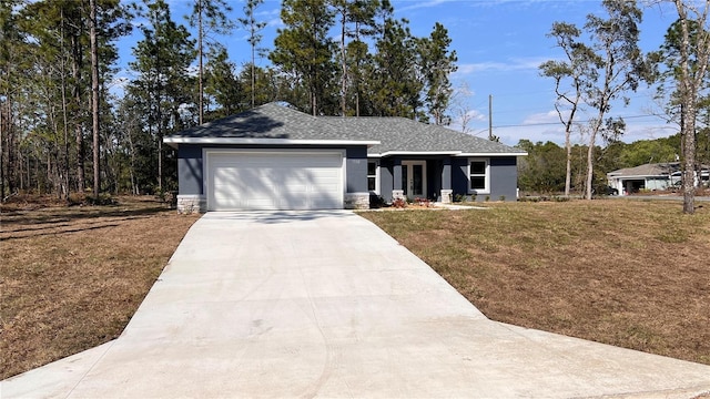 view of front of home featuring a garage, stucco siding, concrete driveway, and a front yard