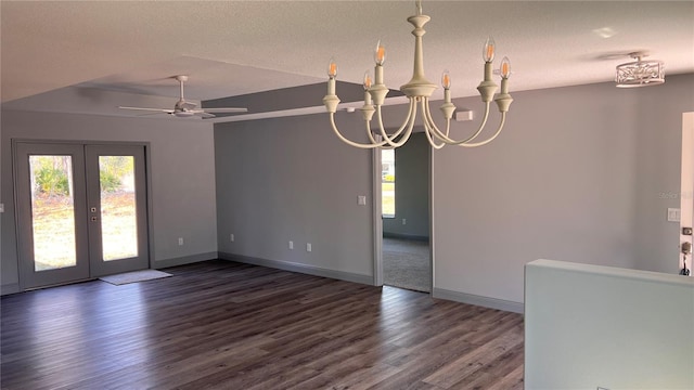 spare room with a textured ceiling, dark wood-type flooring, and baseboards