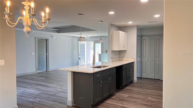 kitchen with white cabinets, open floor plan, wood finished floors, light countertops, and recessed lighting