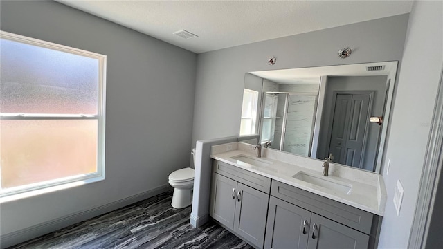 full bathroom with a stall shower, visible vents, a sink, and toilet