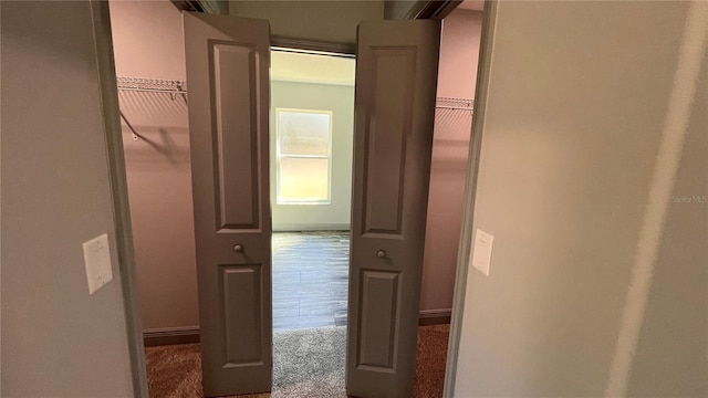 corridor with carpet floors and baseboards