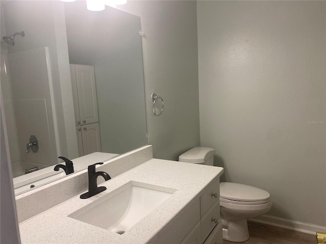 full bathroom with vanity, wood-type flooring, shower / bathtub combination, and toilet