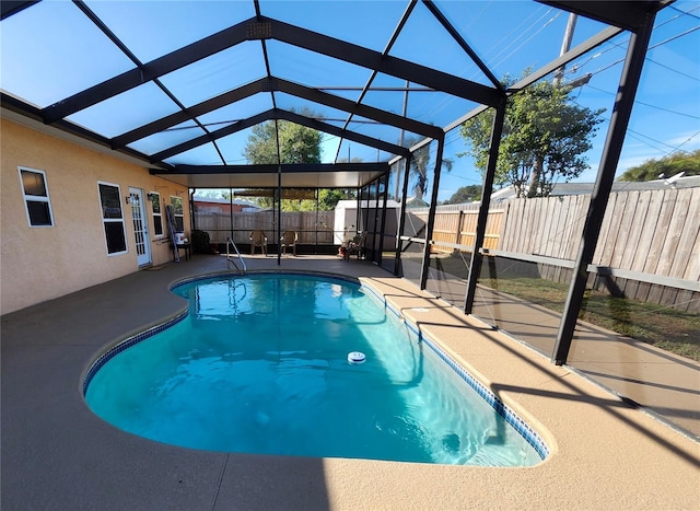 view of swimming pool featuring an outbuilding, a storage unit, a patio area, a lanai, and a fenced backyard