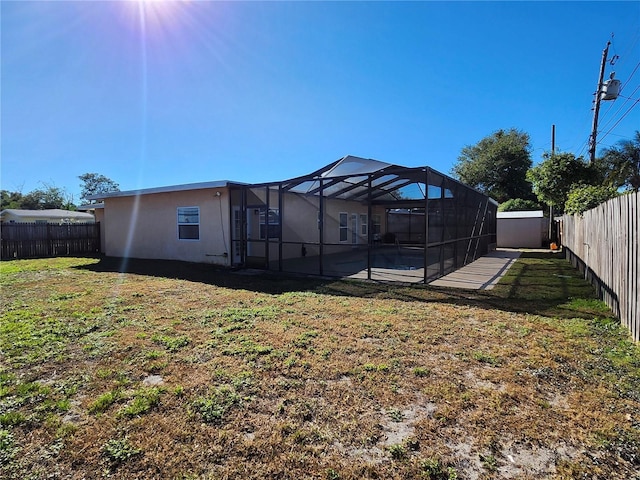 view of yard featuring glass enclosure and a fenced backyard