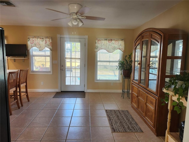 doorway to outside with a healthy amount of sunlight, visible vents, and light tile patterned flooring