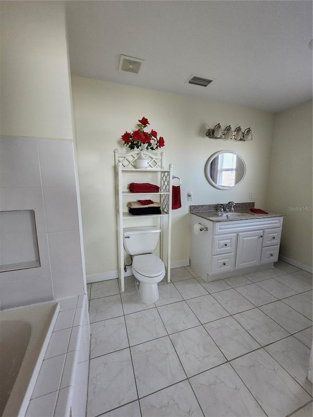 bathroom featuring toilet, tiled bath, vanity, and visible vents