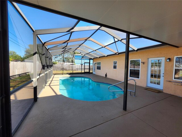 view of swimming pool with a fenced in pool, glass enclosure, a patio area, and a fenced backyard