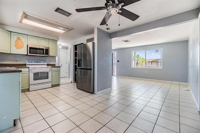 kitchen featuring ceiling fan, light tile patterned flooring, and appliances with stainless steel finishes