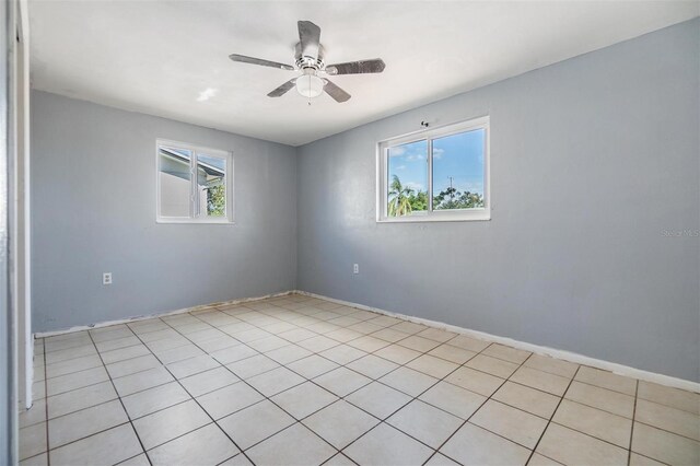 tiled empty room featuring ceiling fan