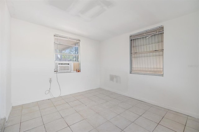 empty room featuring cooling unit and light tile patterned flooring