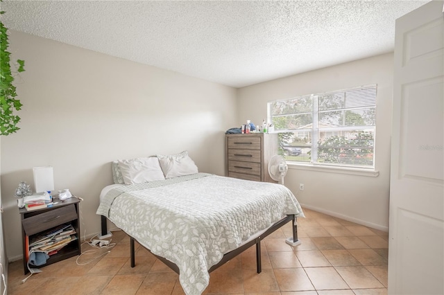 tiled bedroom with a textured ceiling