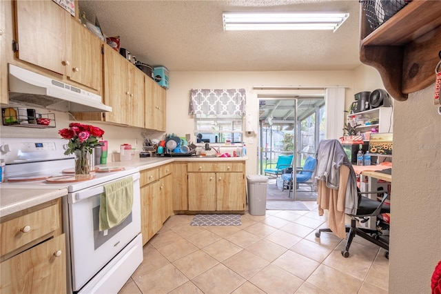 kitchen with electric stove, light brown cabinetry, light tile patterned floors, and a textured ceiling