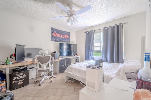 bedroom featuring ceiling fan, light tile patterned floors, and a textured ceiling