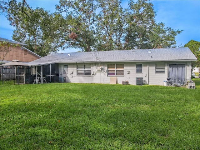 back of house featuring a yard and central AC