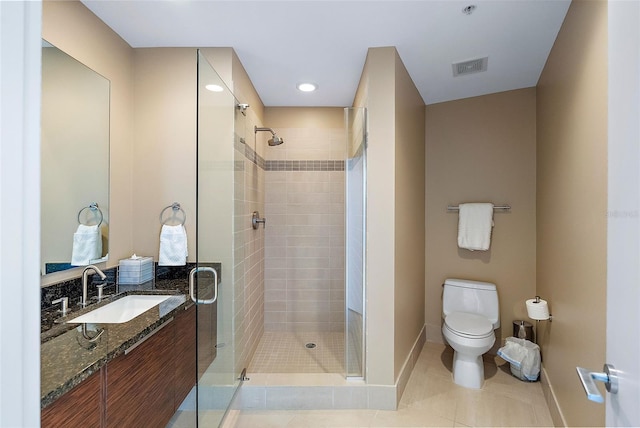 bathroom with tile patterned flooring, vanity, toilet, and a shower with shower door