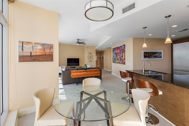 dining area with ceiling fan and sink