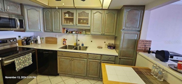 kitchen with stainless steel appliances, ceiling fan, sink, light tile patterned floors, and tile countertops